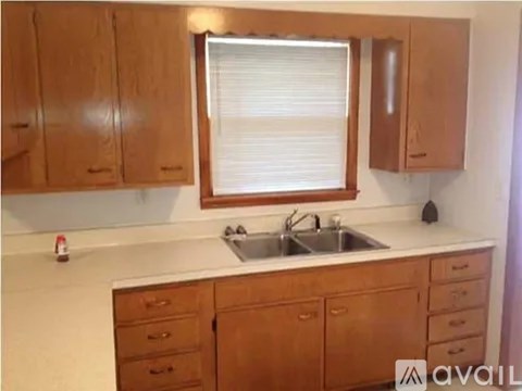 A kitchen with wooden cabinets and a white countertop.