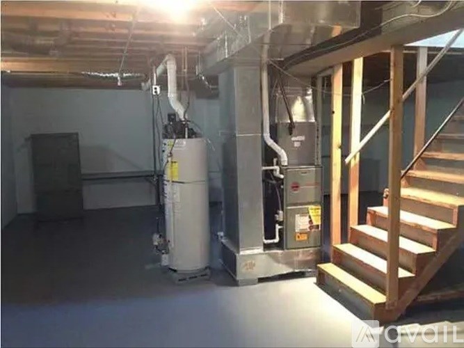 A room with a staircase and a furnace.