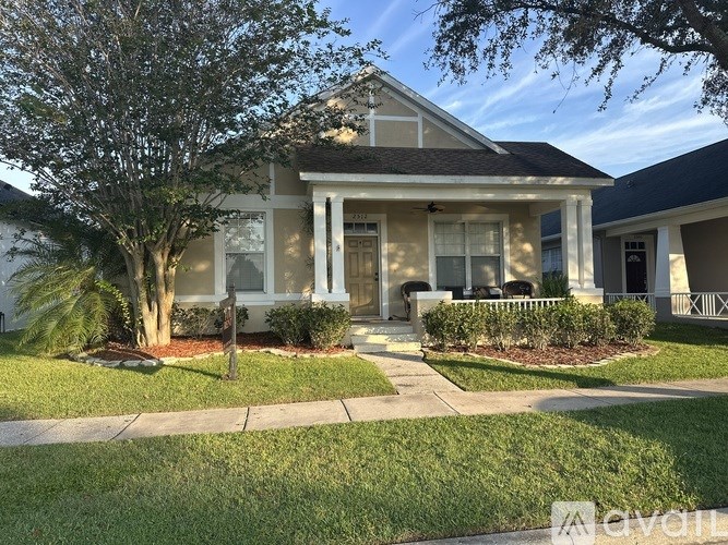 A house with a front yard and a tree.