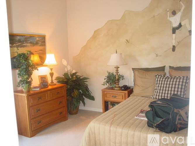 A bedroom with a bed, two nightstands, and a painting on the wall.