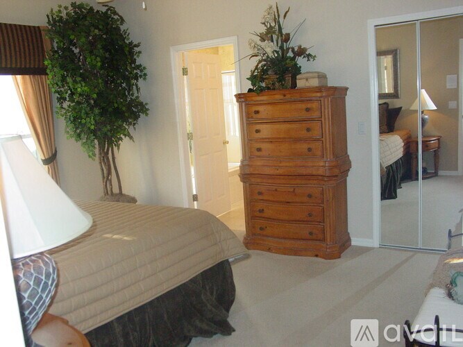 A bedroom with a bed, a dresser, and a mirror.