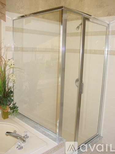 A bathroom with a glass shower door and a sink.