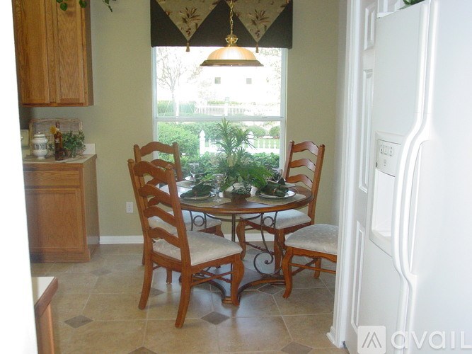 A kitchen with a table and chairs.