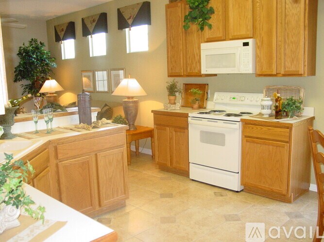A kitchen with wooden cabinets and a white stove.