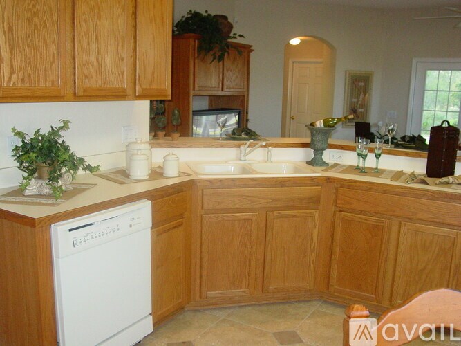 A kitchen with wooden cabinets and a white dishwasher.