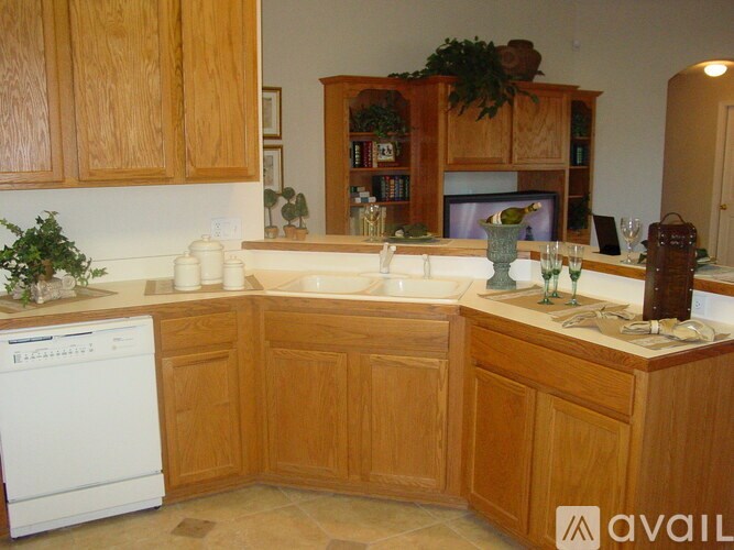 A kitchen with wooden cabinets and a white dishwasher.