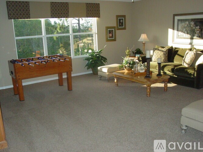 A living room with a pool table and a couch.