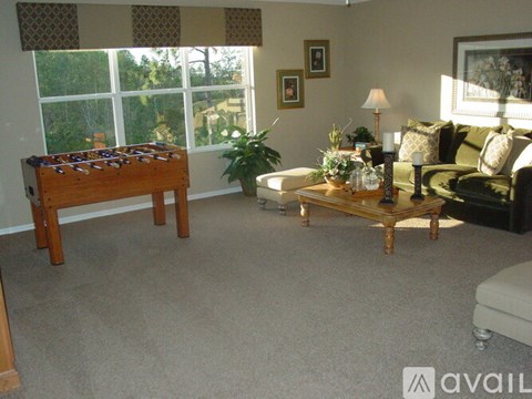 A living room with a pool table and a couch.