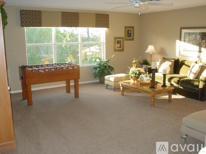 A living room with a couch, coffee table, and a large window.