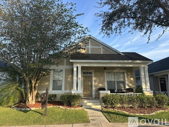 A house with a front yard and a tree.