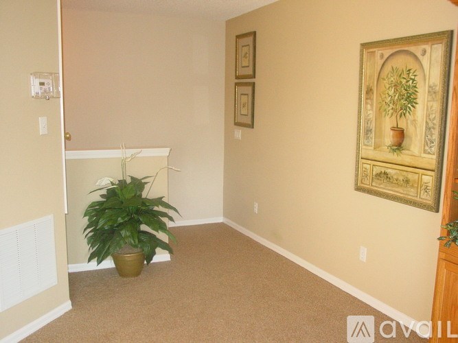 A room with a carpeted floor and a painting on the wall.