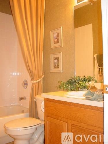 A bathroom with a toilet, sink, and a mirror.