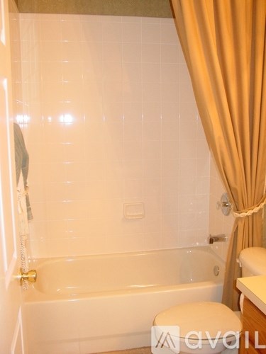 A bathroom with a white tub and toilet.