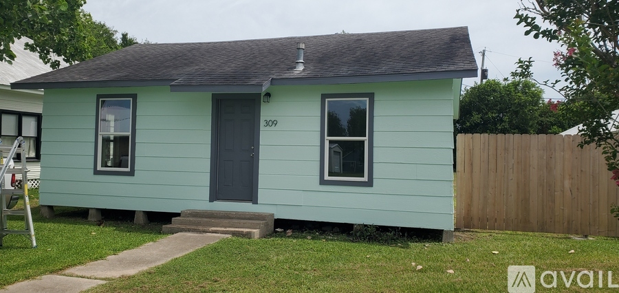 A small blue house with a black door and windows.