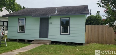 A small blue house with a black door and windows.