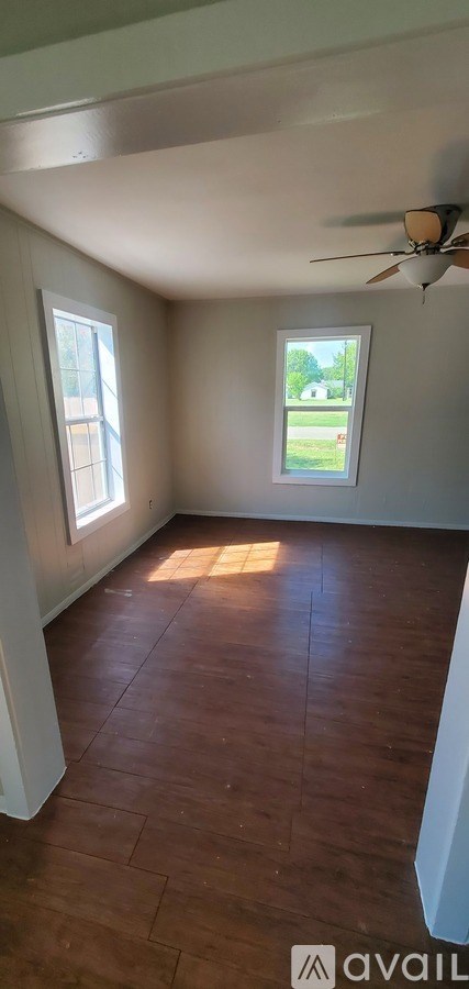 A room with a ceiling fan and a window.