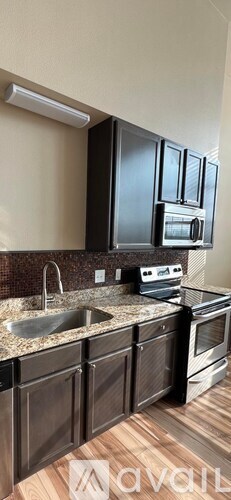 A kitchen with black cabinets and a granite countertop.