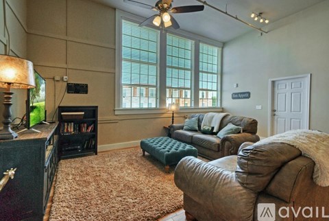 A living room with a fireplace, a couch, a chair, and a rug.