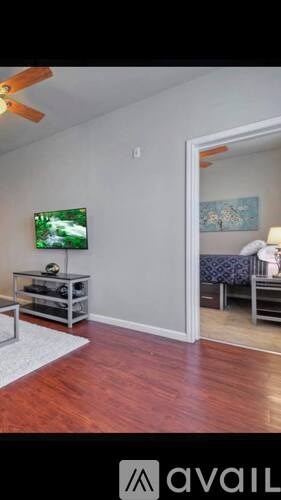 A room with a television and a bed in the background.