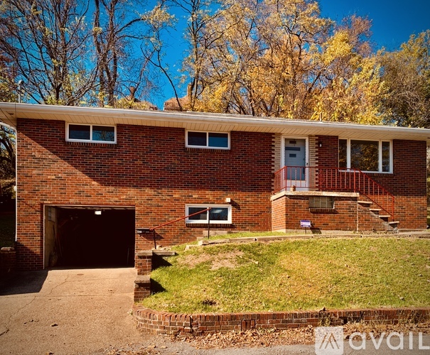 A red brick house with a garage and a small front yard.