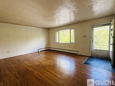A room with wooden floors and a door leading outside.