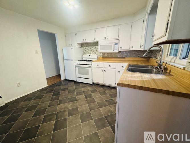 A kitchen with a white fridge, microwave, and oven.