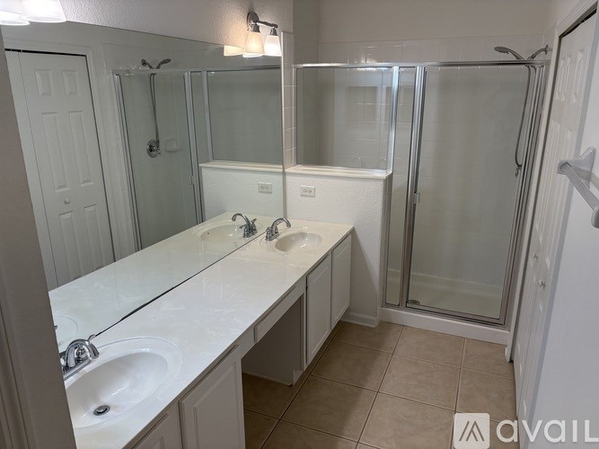 A bathroom with a white countertop and a walk-in shower.