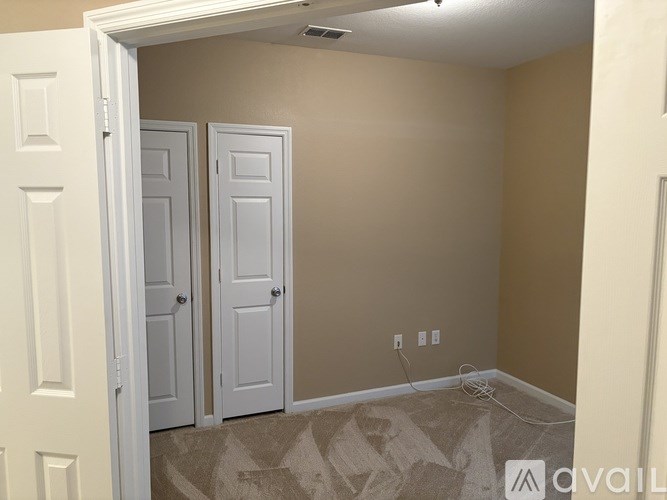 A room with two doors and a carpeted floor.