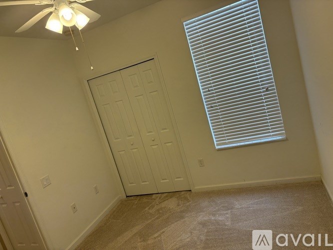 A room with a white door and a window with blinds.