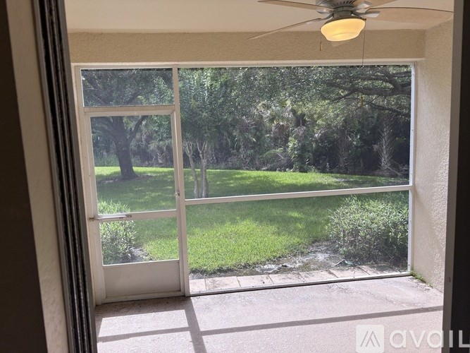A room with a sliding glass door leading to a green outdoor area.