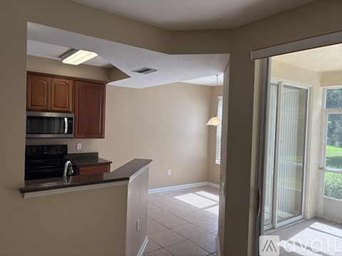 A kitchen with brown cabinets and a black countertop.