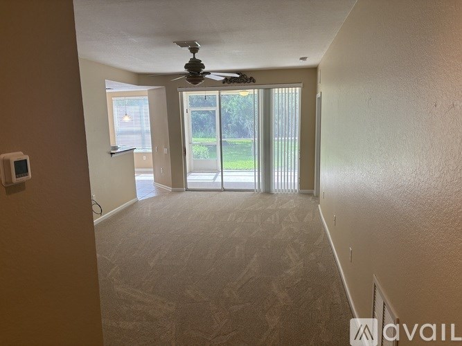 A room with a ceiling fan and sliding glass doors leading to a patio.
