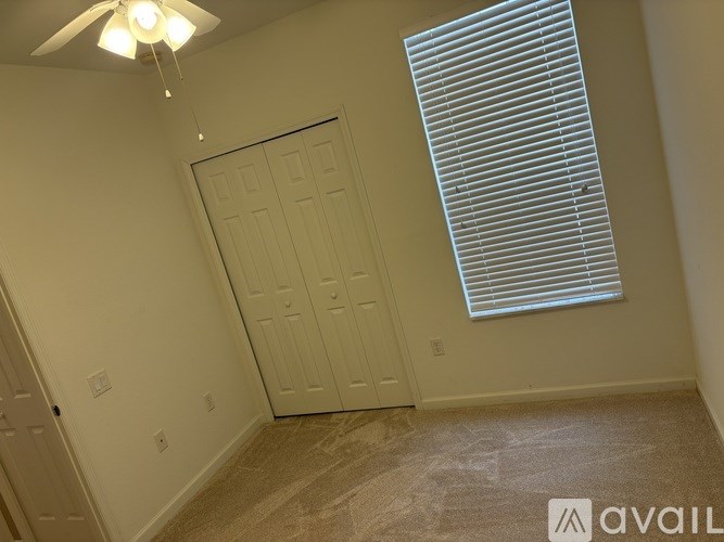 A room with a white door and a window with blinds.