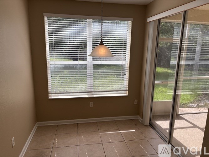 A room with a sliding glass door leading to a backyard.