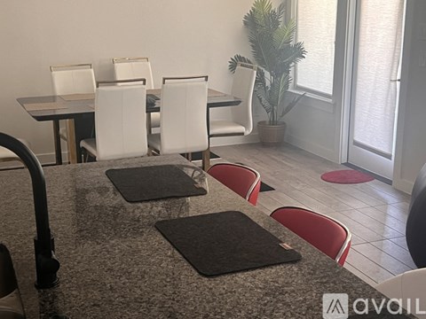 A dining room with a table and chairs.