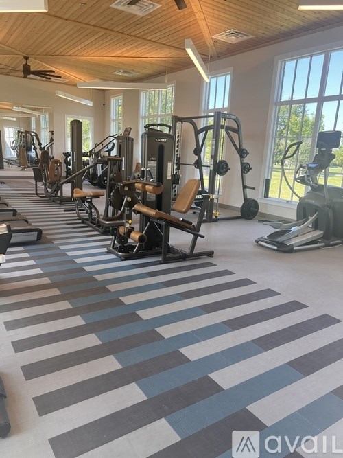 A gym with a variety of equipment including treadmills, weights, and exercise machines.