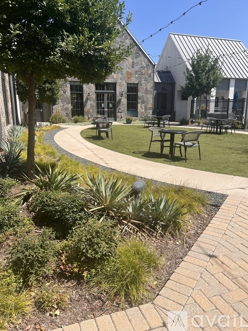 A garden with a stone building in the background.