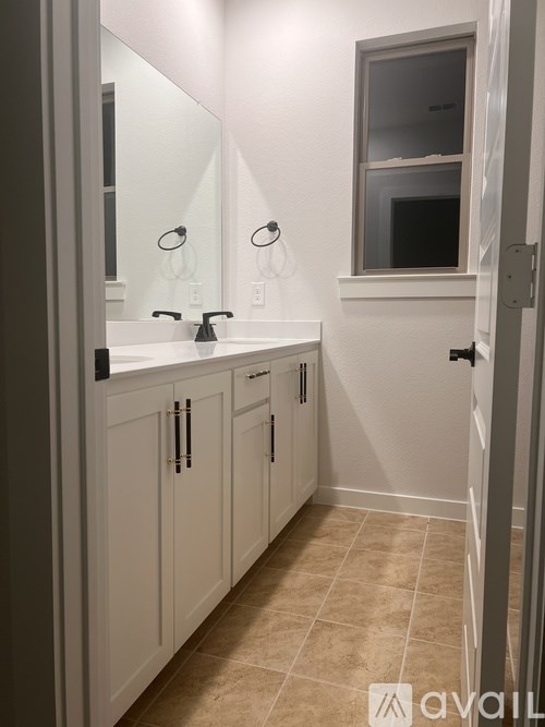 A bathroom with a sink, mirror, and cabinets.