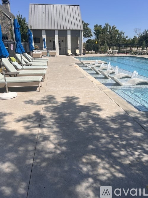 A poolside area with sun loungers and a building in the background.