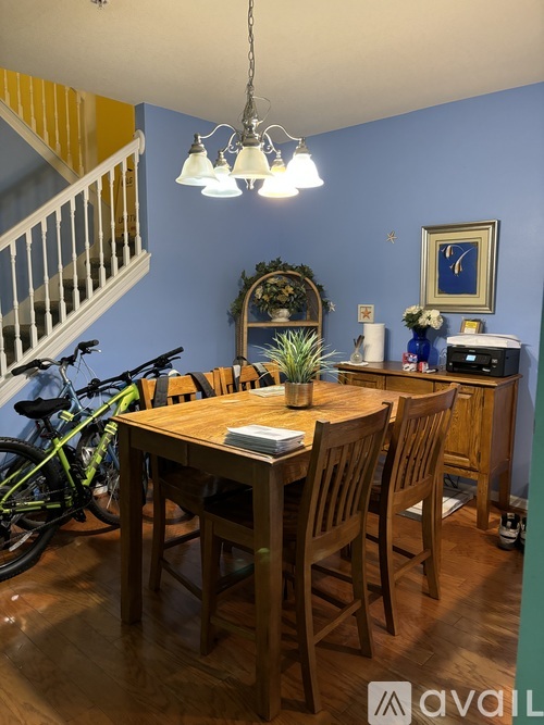 A dining room with a wooden table and chairs.