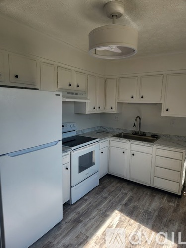 A kitchen with white appliances and cabinets.
