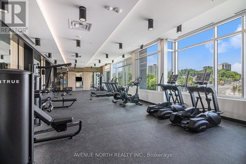 A gym with a row of treadmills and a row of stationary bikes.