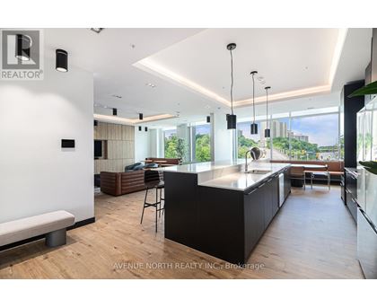 A modern kitchen with a bar stool and a view of the city.