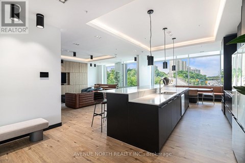 A modern kitchen with a bar stool and a view of the city.