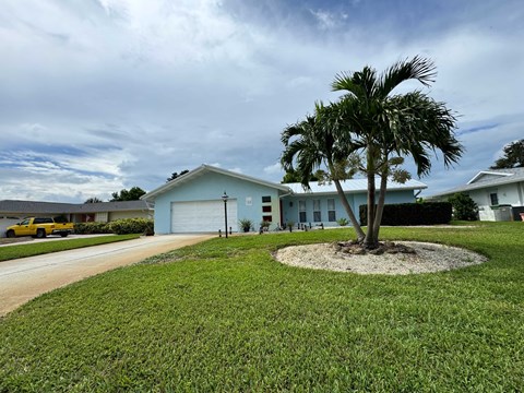 A house with a palm tree in front.