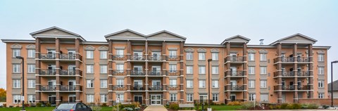 A large apartment building with multiple balconies and doors.