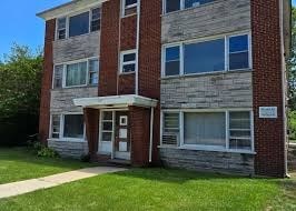 A brick building with a white door and windows.