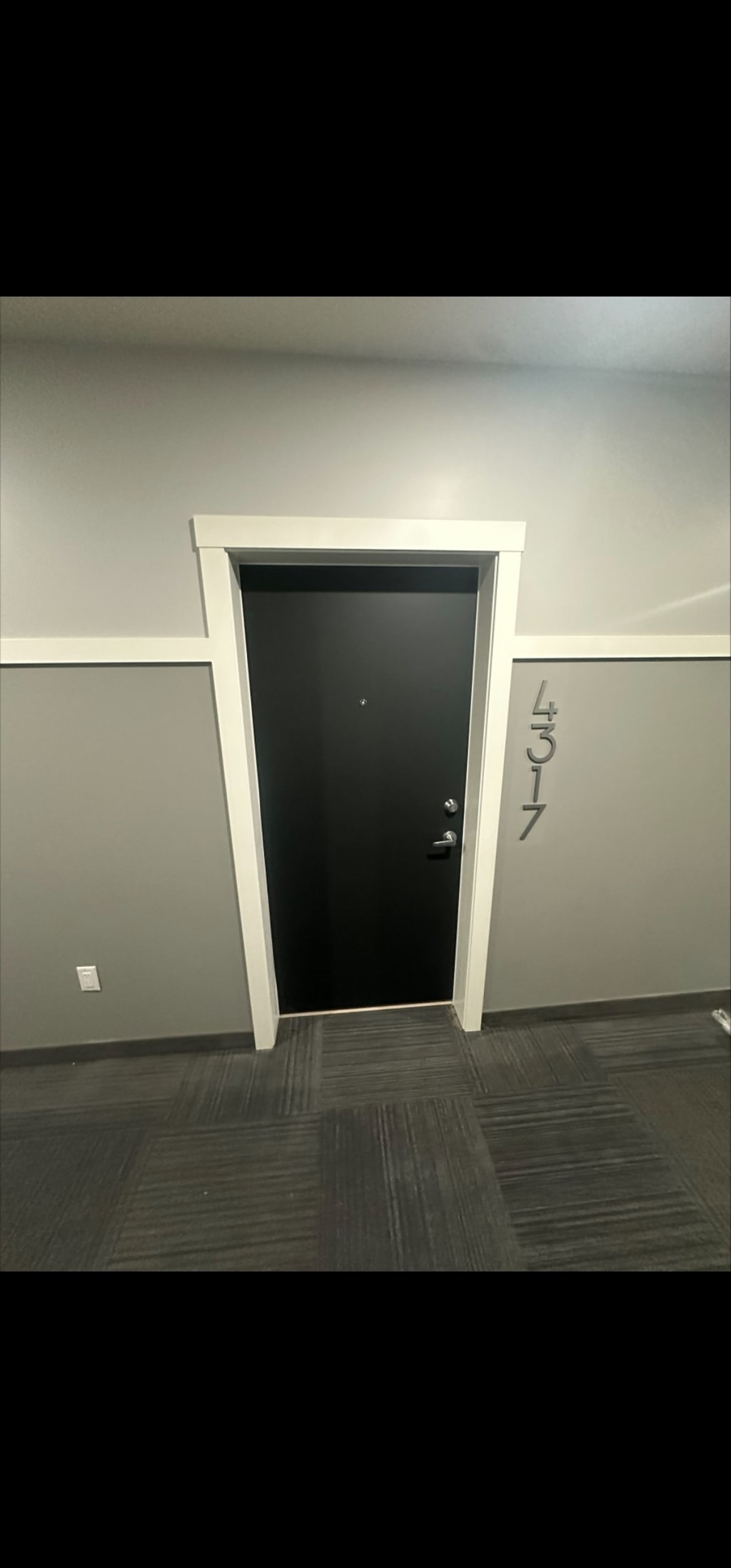 A black door is in a white frame.