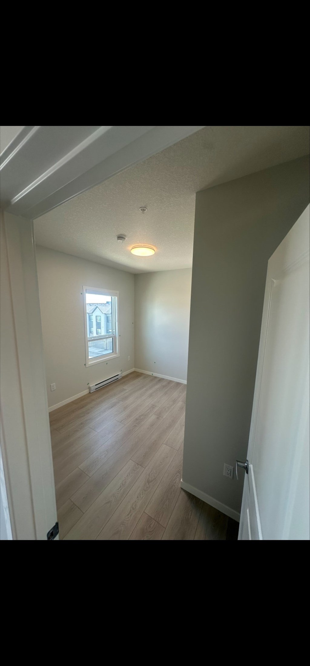 A room with wooden flooring and a window.