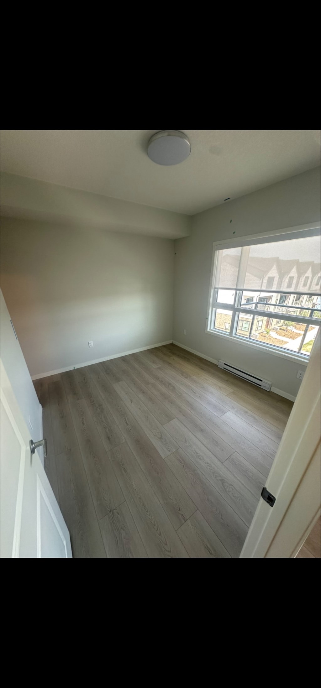 A room with wooden flooring and a window.